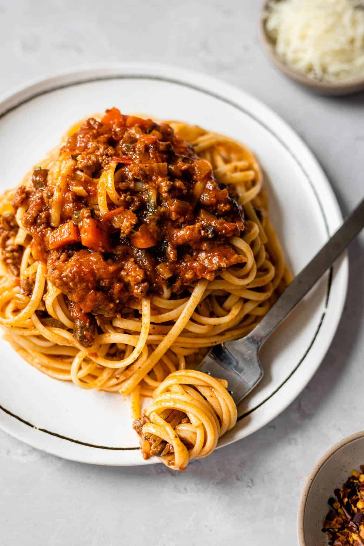 plate of a single serving of linguine topped with bolognese sauce