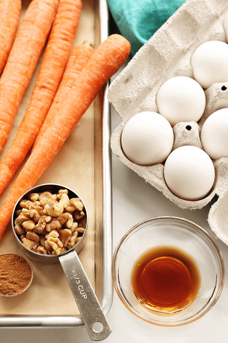 Key ingredients for making carrot sheet cake: eggs, vanilla extract, walnuts, carrots