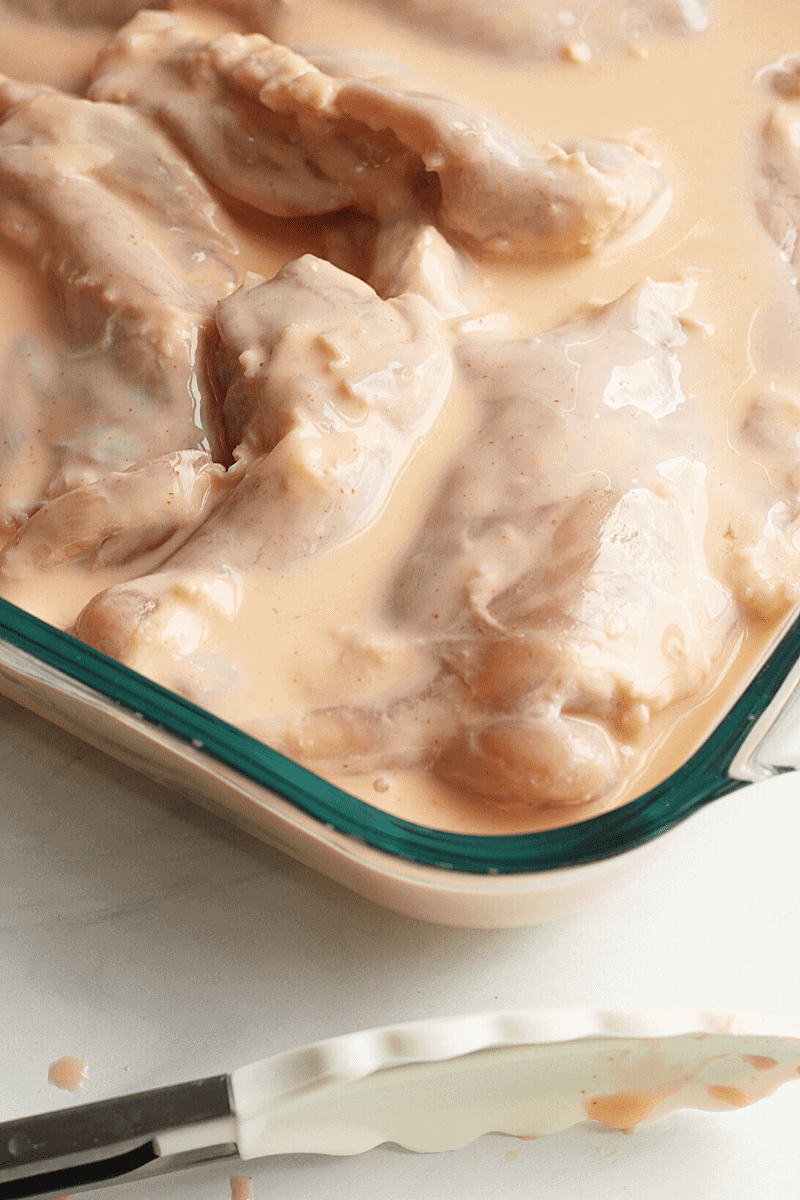 Chicken thighs marinating in buttermilk.