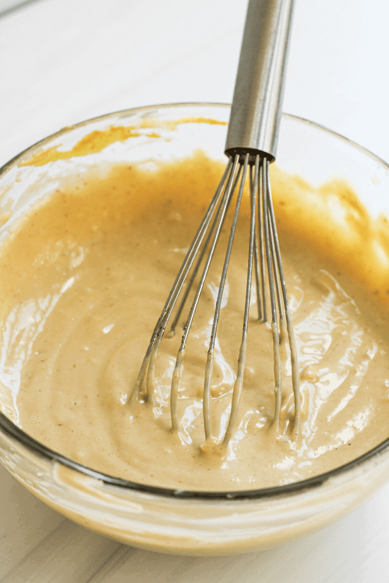 Closeup that shows the color and consistency of homemade caesar dressing