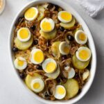 Bacalhau (salted cod) with chickpeas in a white dish.