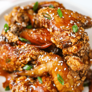 This is a close-up (macro-shot) of Crispy, Spicy Orange-Glazed Sticky Wings. The purpose of the photo is to show detail and entice the reader