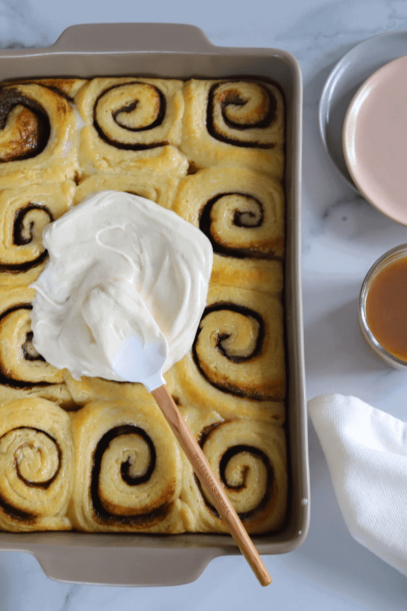 frosting the cinnamon rolls