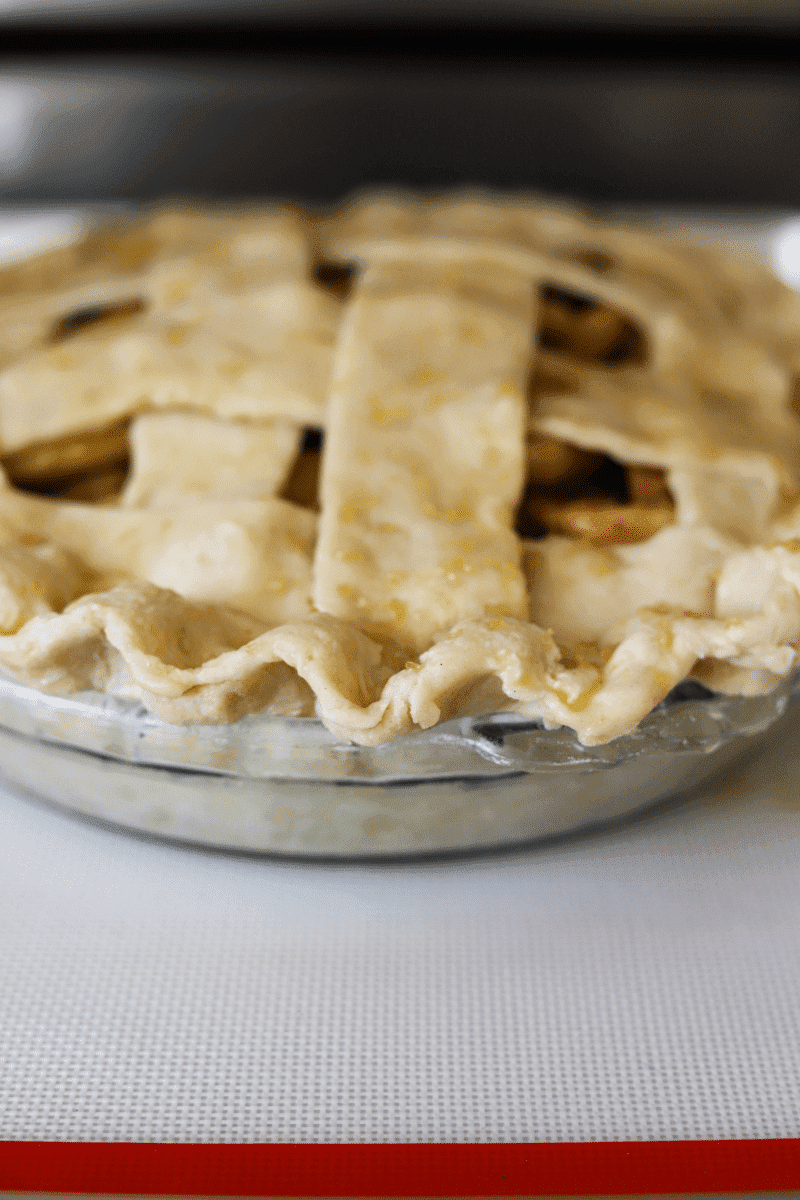 This is a close up photo of an unbaked apple pie with a lattice crust