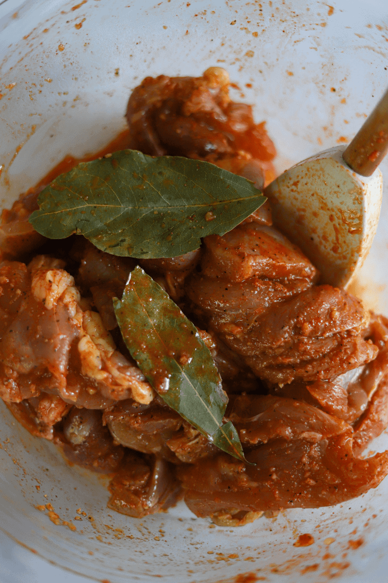 close up shot of seasoned chicken thighs in preparation for making Cape Verdean canja