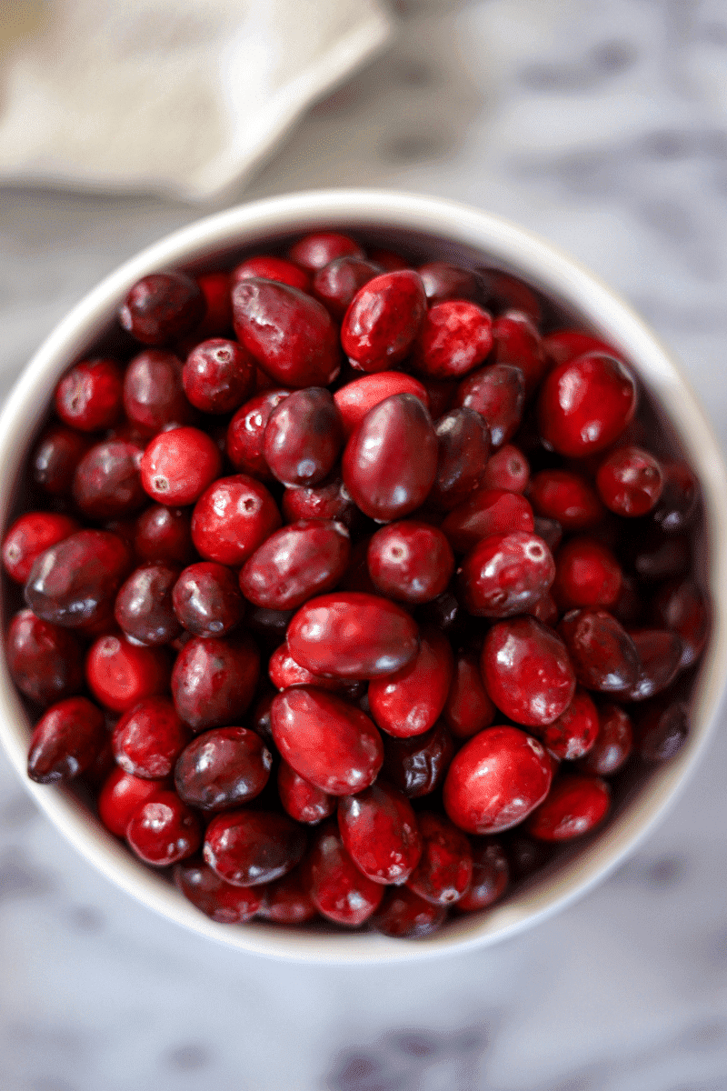 close up of fresh cranberries in a bowl, this is the main ingredient in spiked homemade cranberry sauce