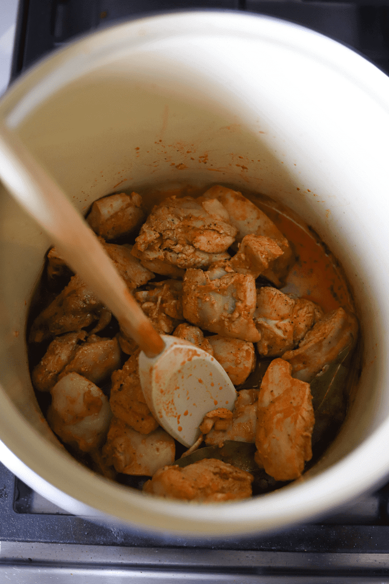 Stewing chicken in a pot to make Cape Verdean Canja