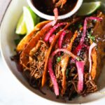 platter of birria tacos with consomme and fresh limes