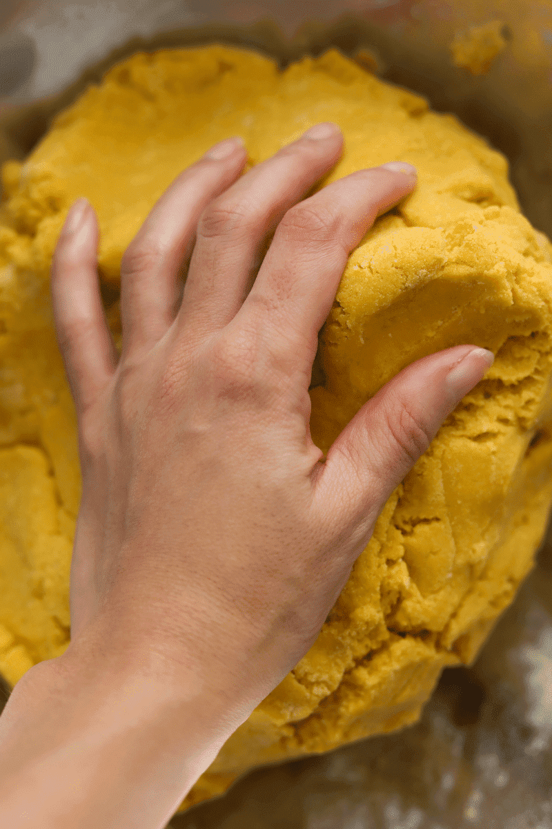 Cape Verdean gufong dough made of sweet potato and cornmeal. The author's hand is shown working the dough.