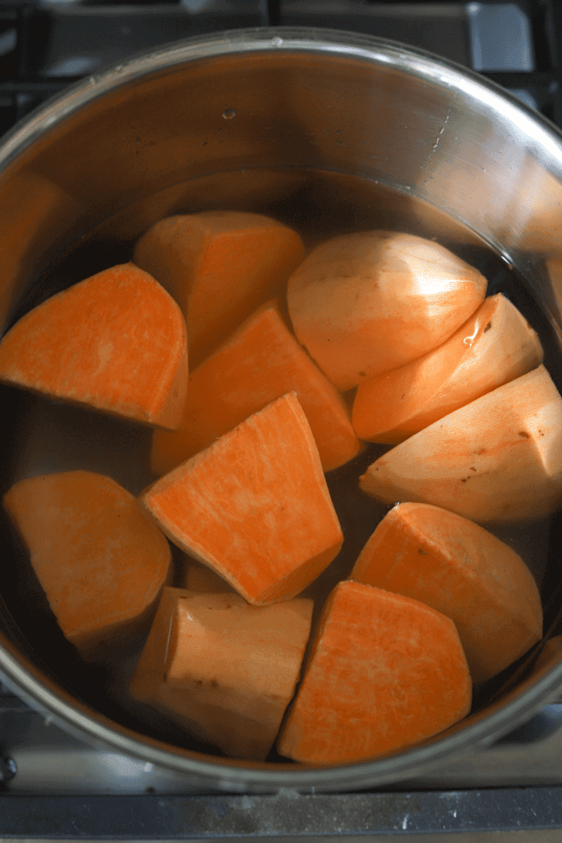 Cut and peeled sweet potatoes in a pot of water, in preparation for making Cape Verdean gufong