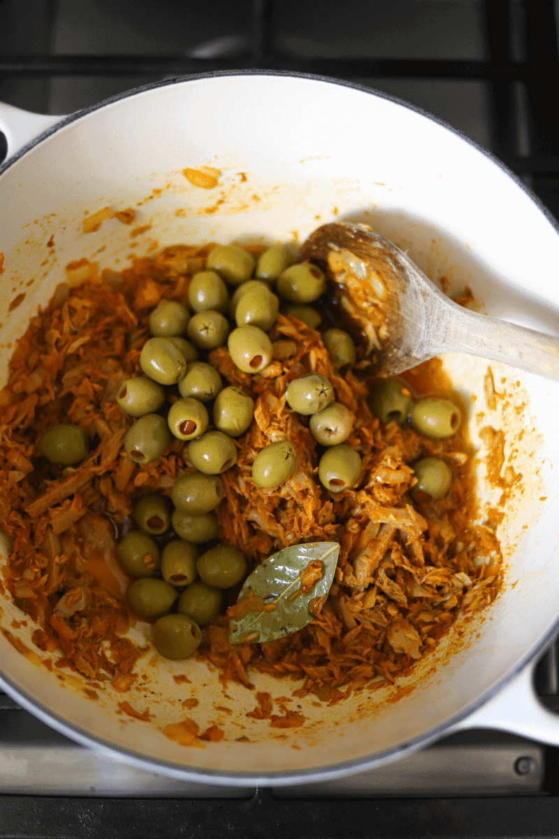 overhead shot of spanish olives being mixed into the tuna (this is before the rice is added)