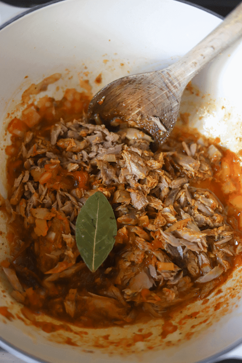 This is a photo of the tuna and seasoning being combined with the onions, garlic and bay leaf in preparation of Cape Verdean rice with tuna (arroz de atum)