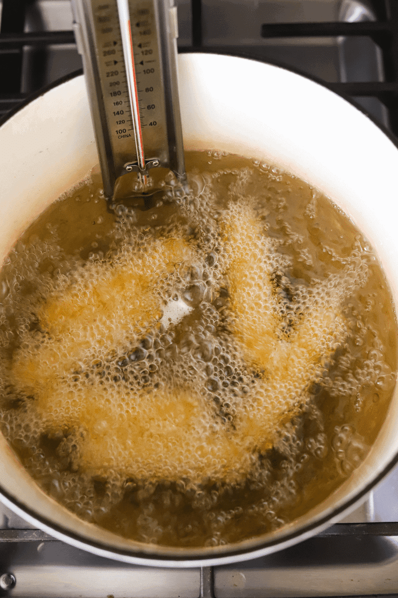 6 gufong frying in a dutch oven on the stove