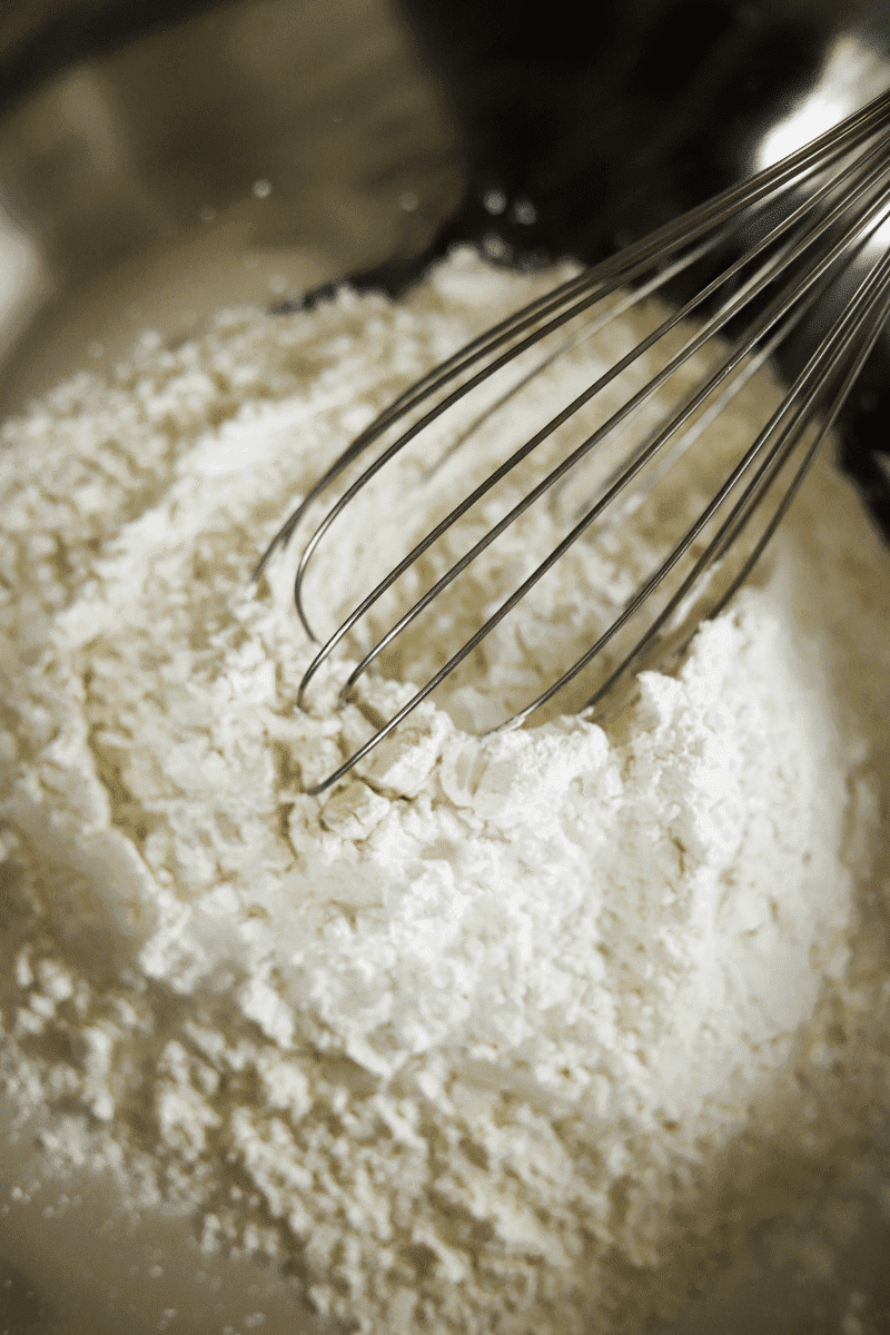 A photo of the cornstarch and flour being whisked in a large metal bowl