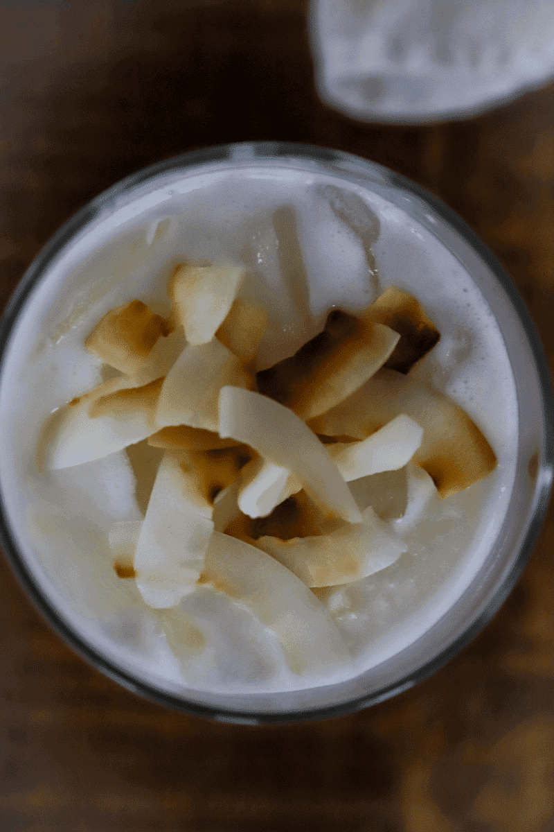 glass of Cape Verdean coconut pontche garnished with toasted coconut flakes