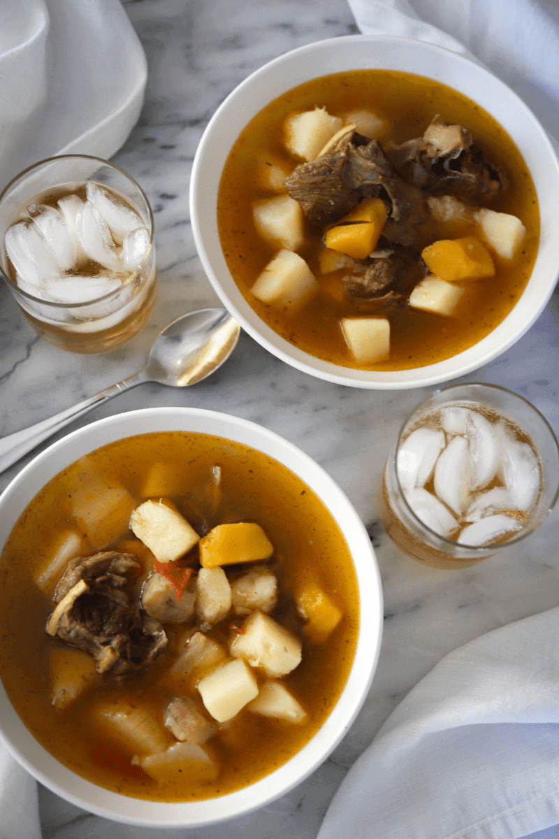 This is an overhead photo of 2 bowls of modje (Cape Verdean goat and lamb stew with root vegetables)