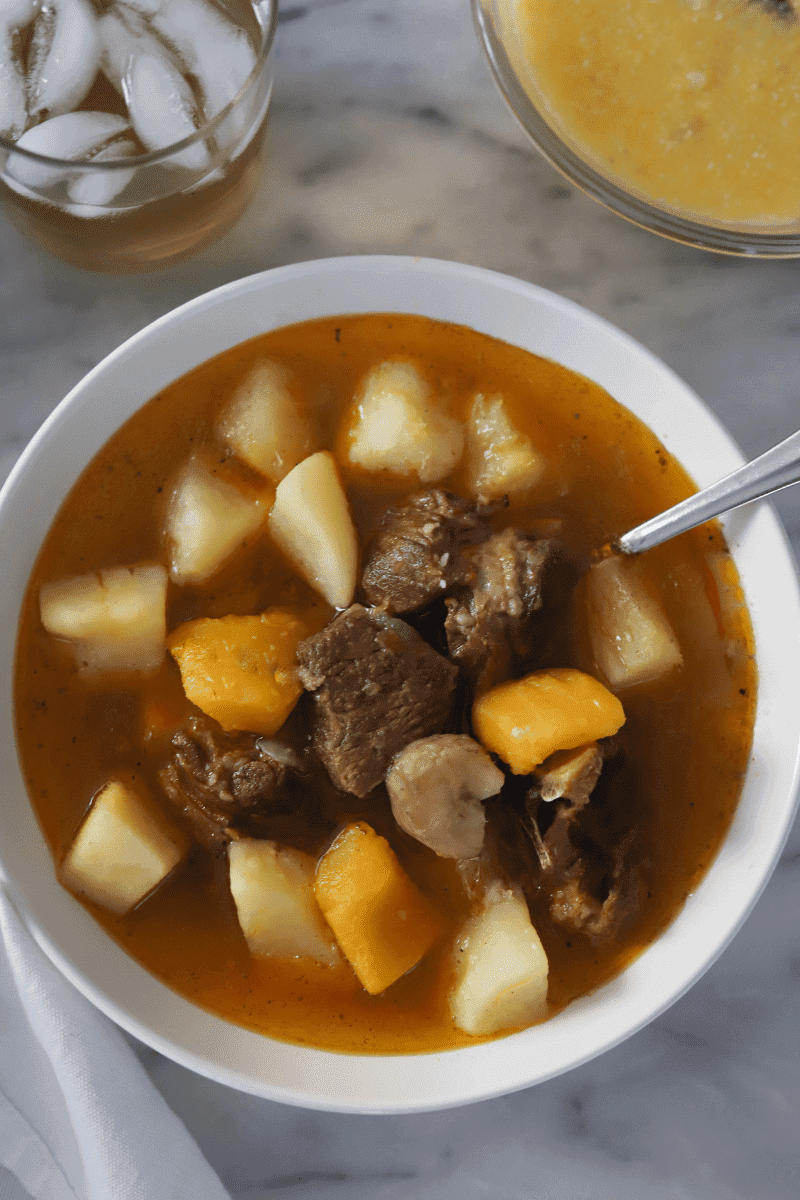 This is a close up photo of a bowl of modje (Cape Verdean goat and lamb stew with root vegetables)