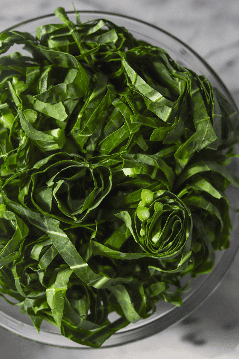 This is a close up phpto that shows you how thinly to slice the collard greens for this caldo verde recipe.