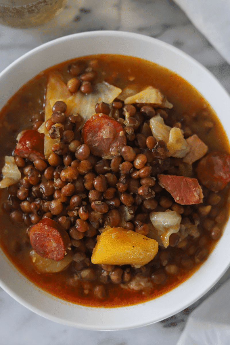 Close up of Cape Verdean stewed pigeon peas (feijão congo) in a white bowl on a marble background