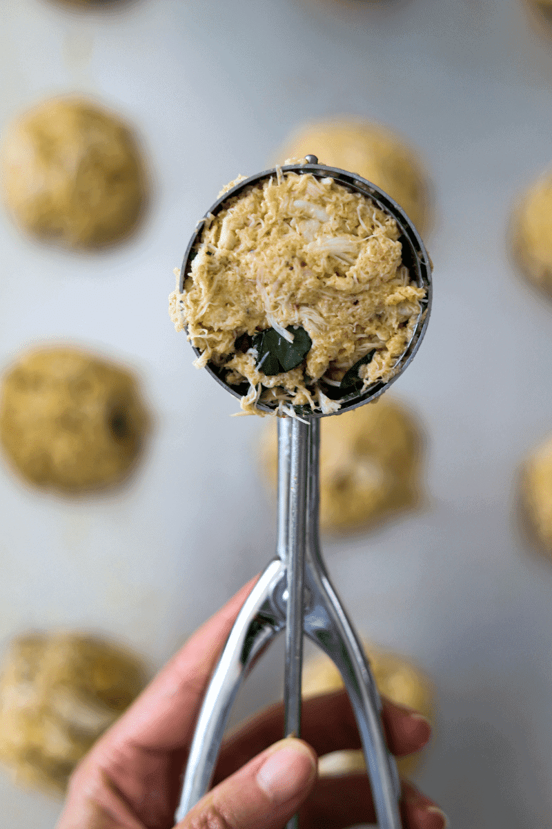 mound of crab cake mixture in a metal ice cream scoop.