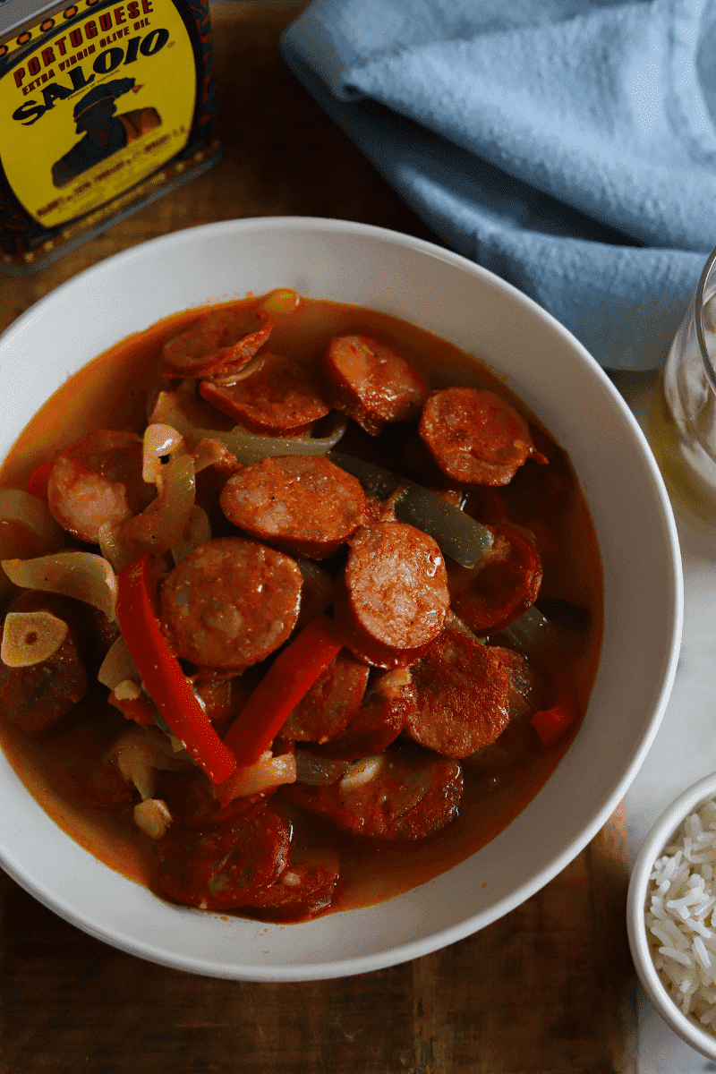 bowl of linguiça with onions and peppers in sauce