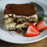 easy classic tiramisu recipe- slice on white plate with strawberry garnish