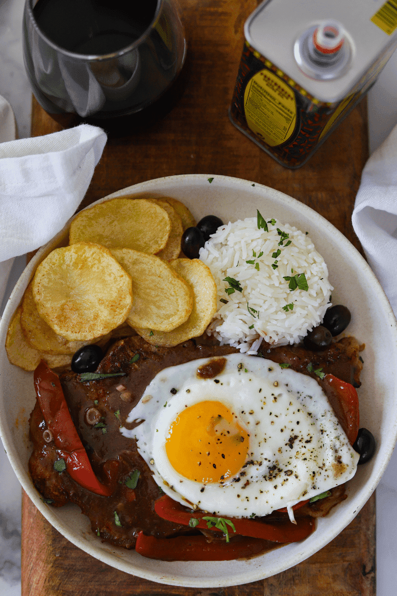 bitoque (portuguese steak) topped with egg and served with rice and fried potatoes