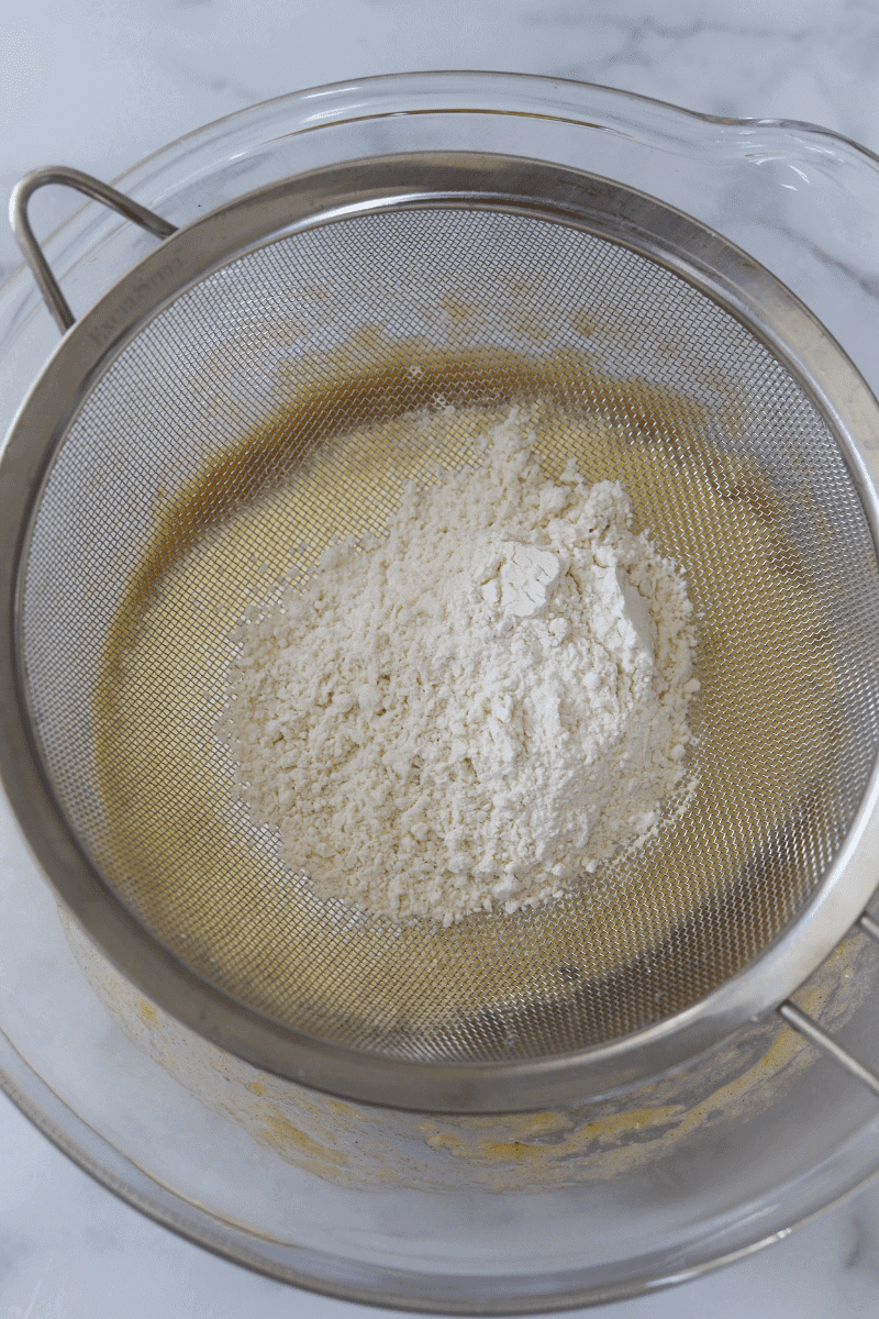 bowl of mashed bananas, sifted cornmeal and sifted flour to make Cape Verdean banana fritters (brinhola)