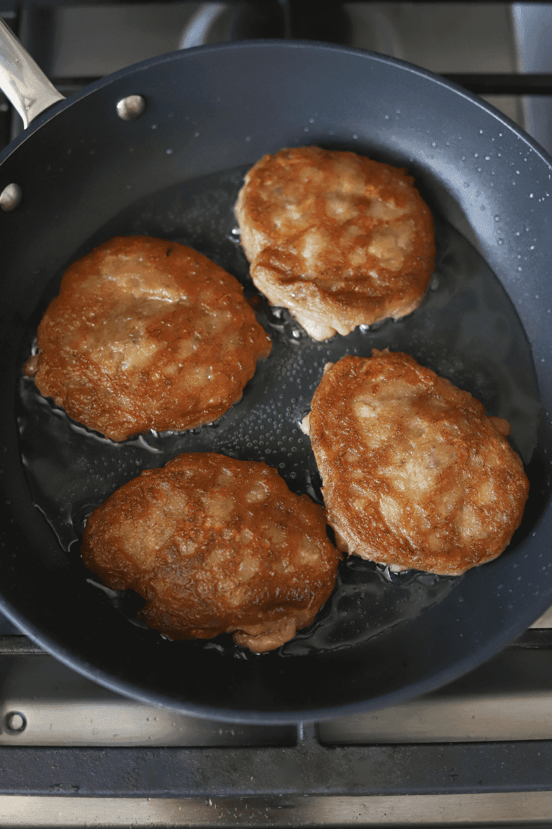 Golden brown Cape Verdean banana fritters (brinhola) frying in a non-stick skillet