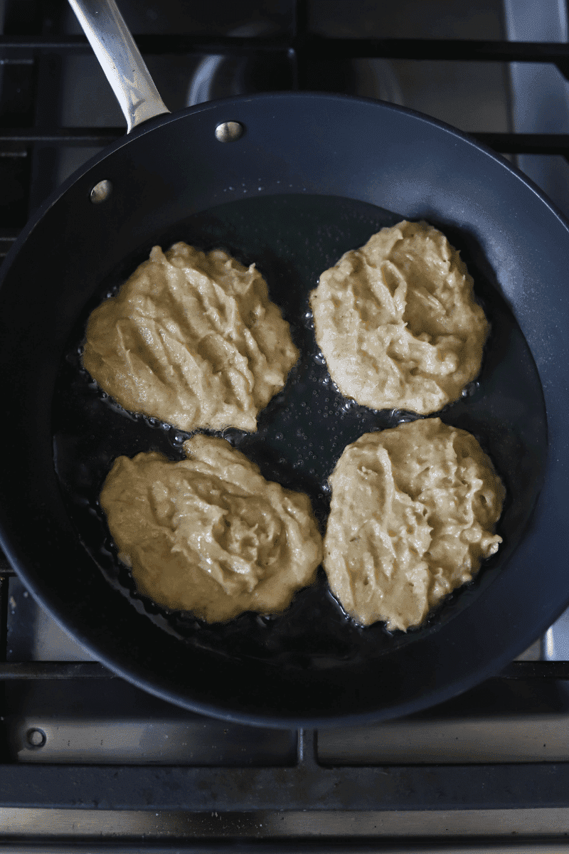 Cape Verdean banana fritters (brinhola) frying in a non-stick skillet