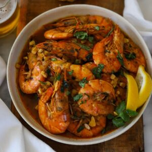 shrimp mozambique on a platter garnished with lemon