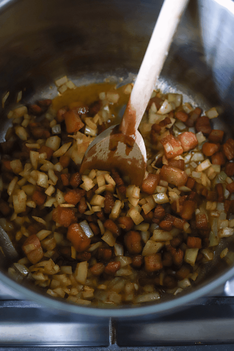 process shot showing salt pork and onions cooking in a stock pot