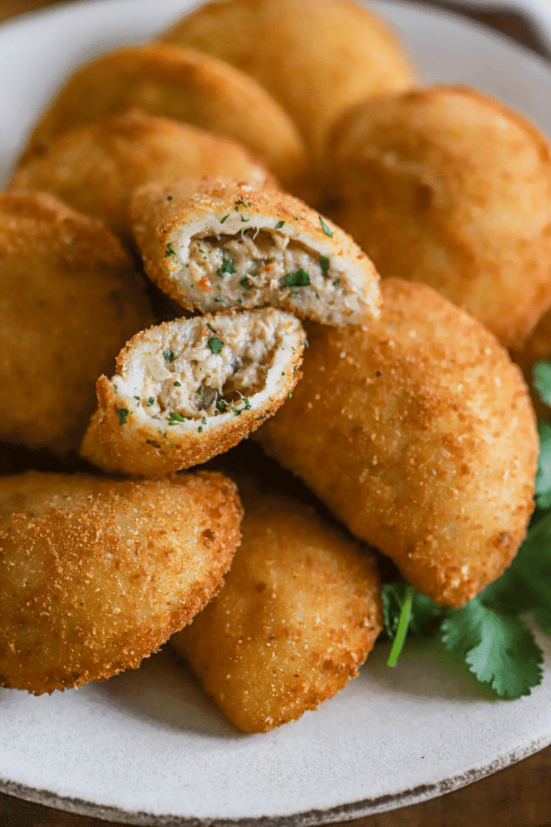 final presentation of fried tuna rissois on a plate with cilantro garnish
