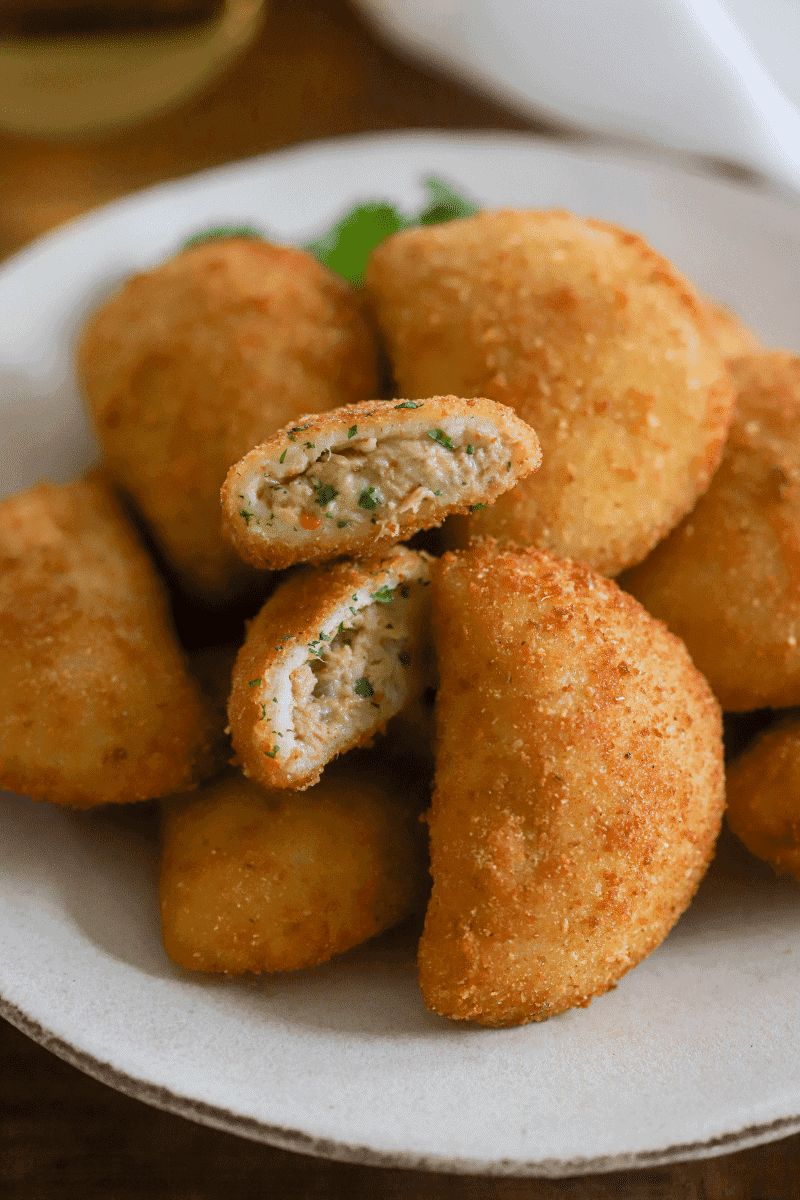 final presentation of fried tuna rissois on a plate with cilantro garnish