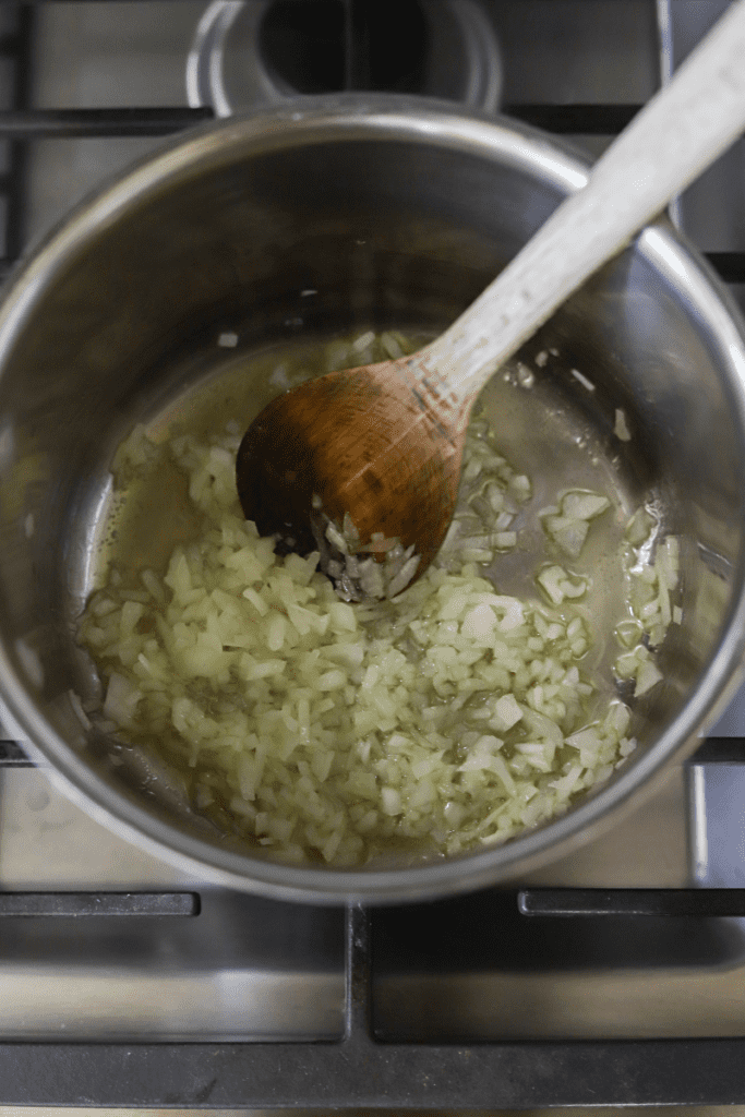 overhead shot of cooked onions in a pan for tuna rissois