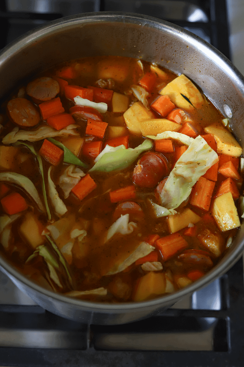 process shot of feijoada in early cooking stages with meat and vegetables