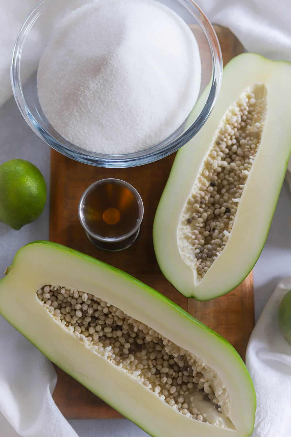 photo of ingredients needed to make green papaya jam recipe: granulated sugar, rum, limes, molasses are not shown.