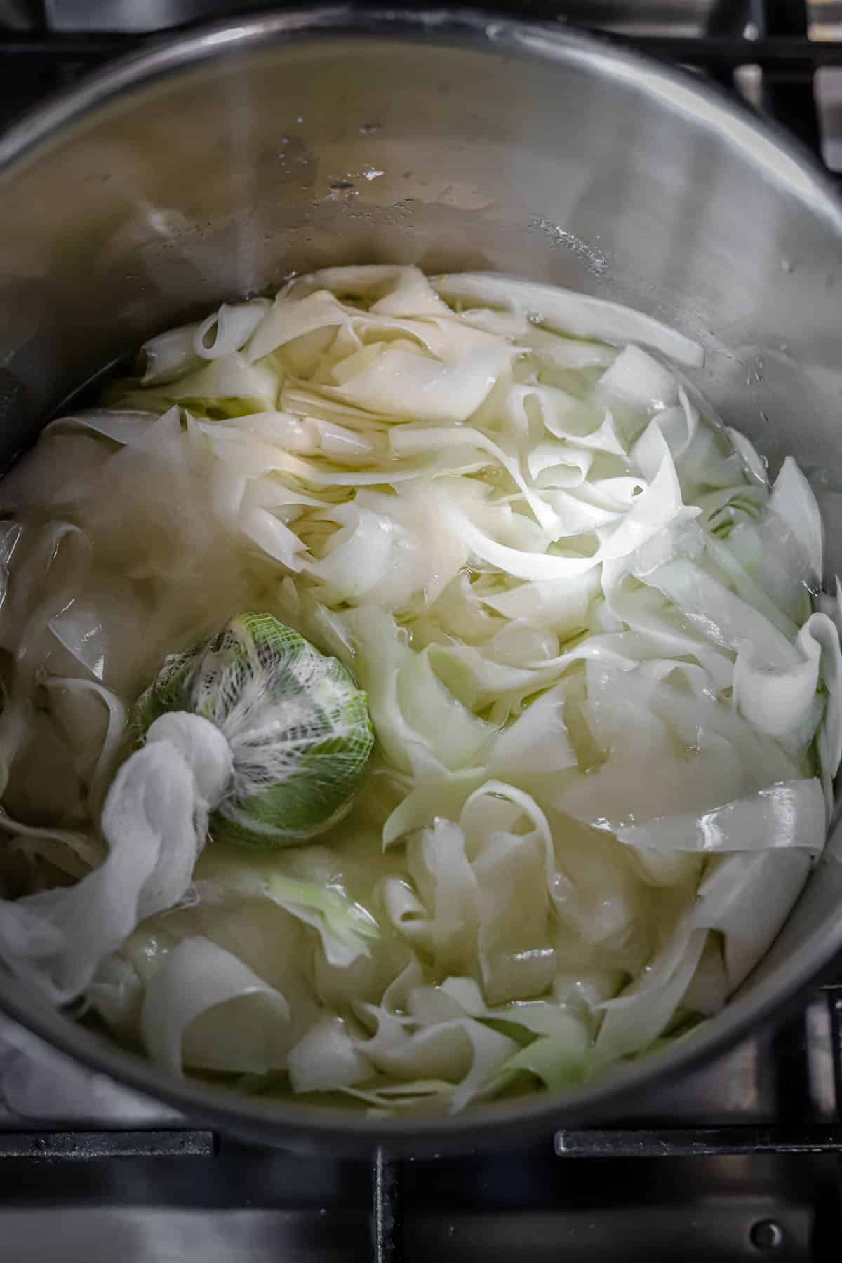 process photo of shredded green papaya in a stock pot in preparation of papaya jam