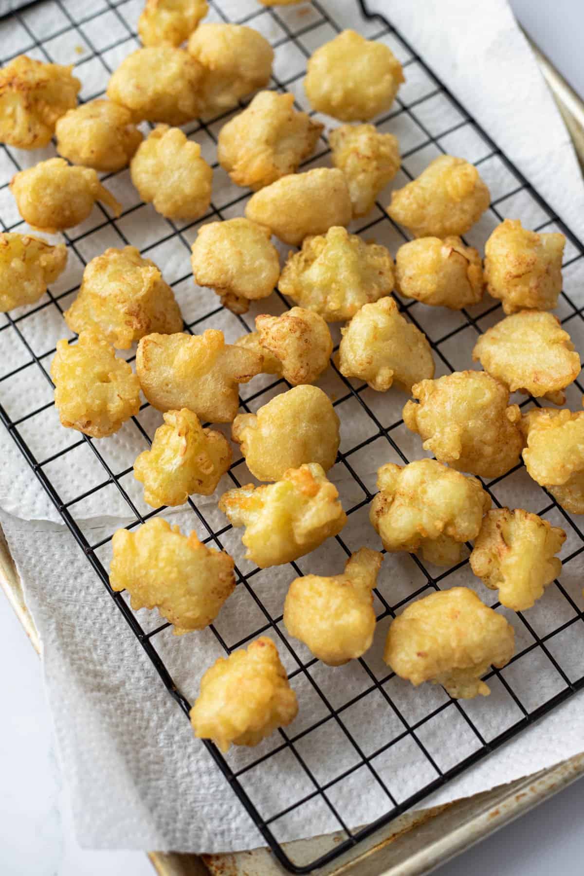 vegan battered cauliflower on a metal cooling rack