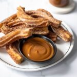 plate of churros with dulce de leche dipping sauce