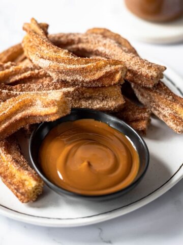 plate of churros with dulce de leche dipping sauce