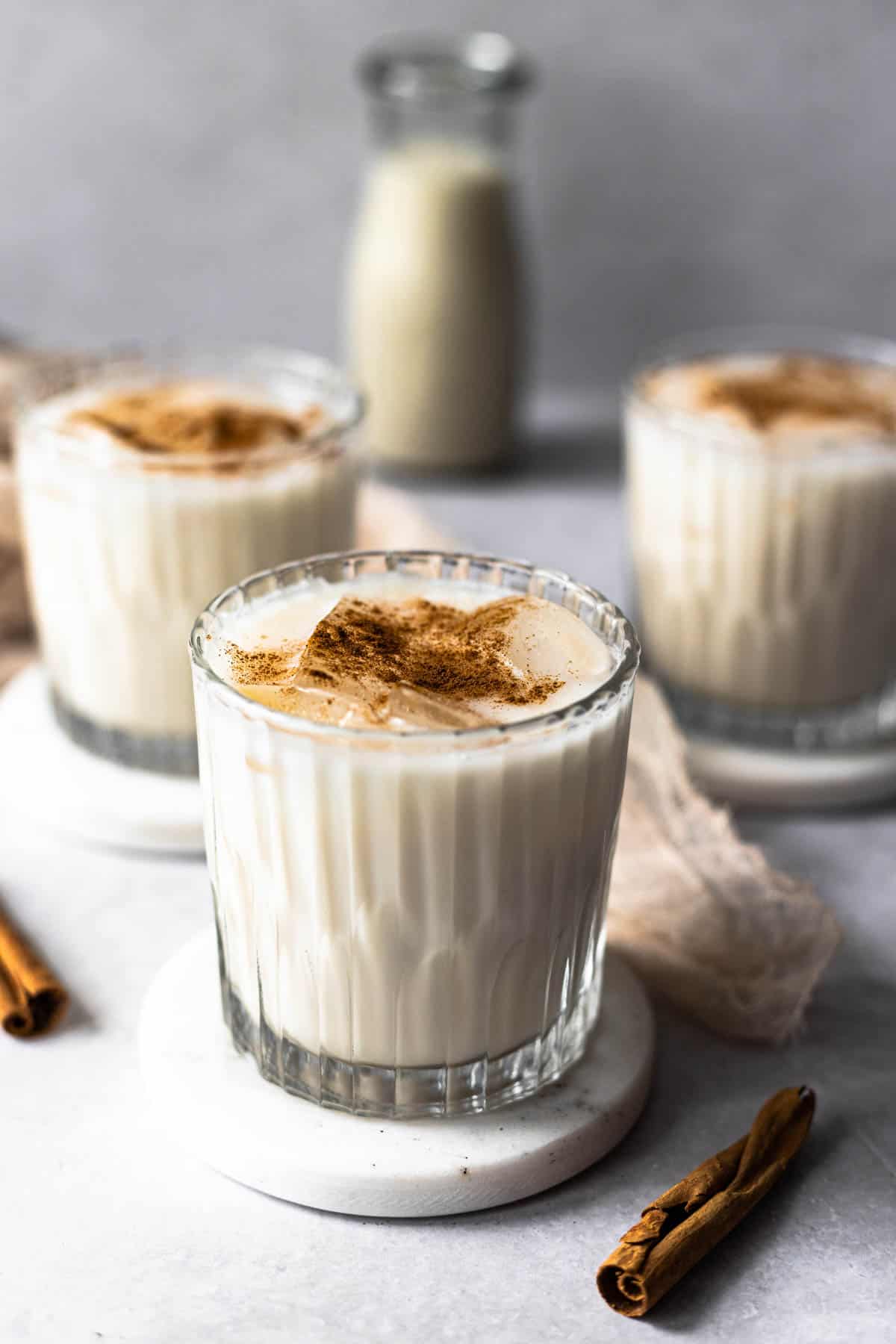 3 glasses of agua de horchata over ice, garnished with cinnamon