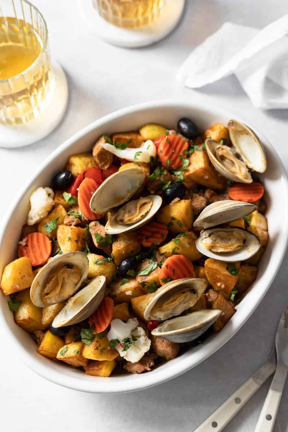 platter of carne de porco a alentejana served with clams, fried and fried potatoes