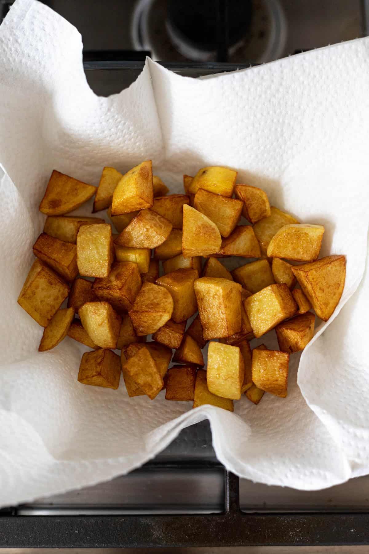 fried potatoes on a paper towel lined plate