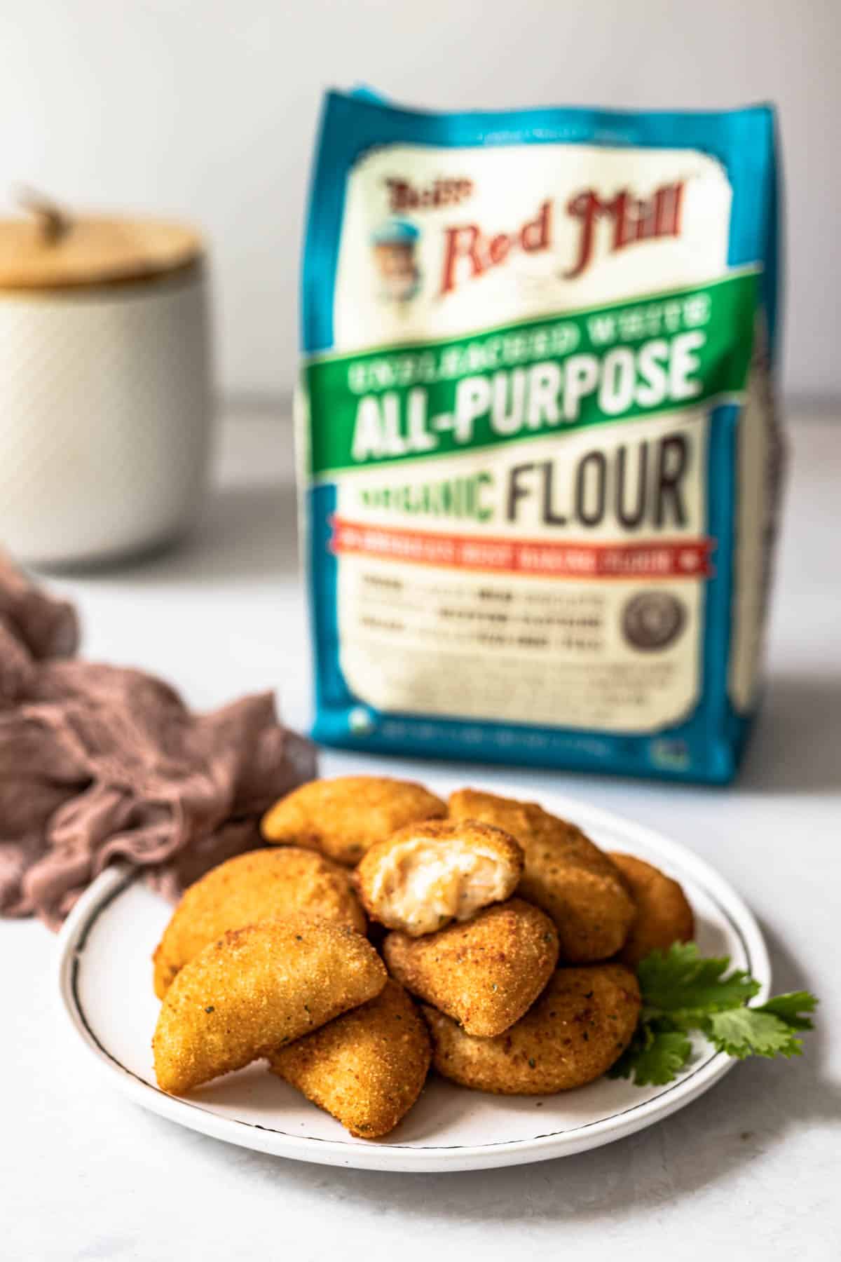 plate of shrimp rissois with a bag of flour in the background