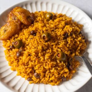 pigeon peas and rice with olives on a white plate