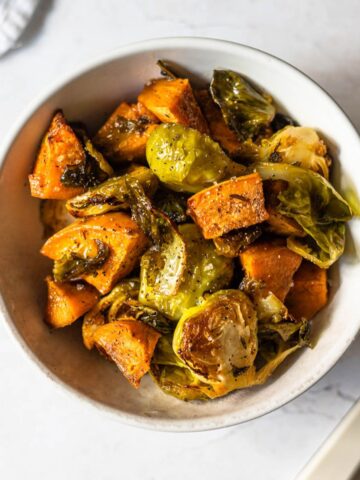 roasted brussels sprouts and sweet potatoes sprinkled with salt and pepper