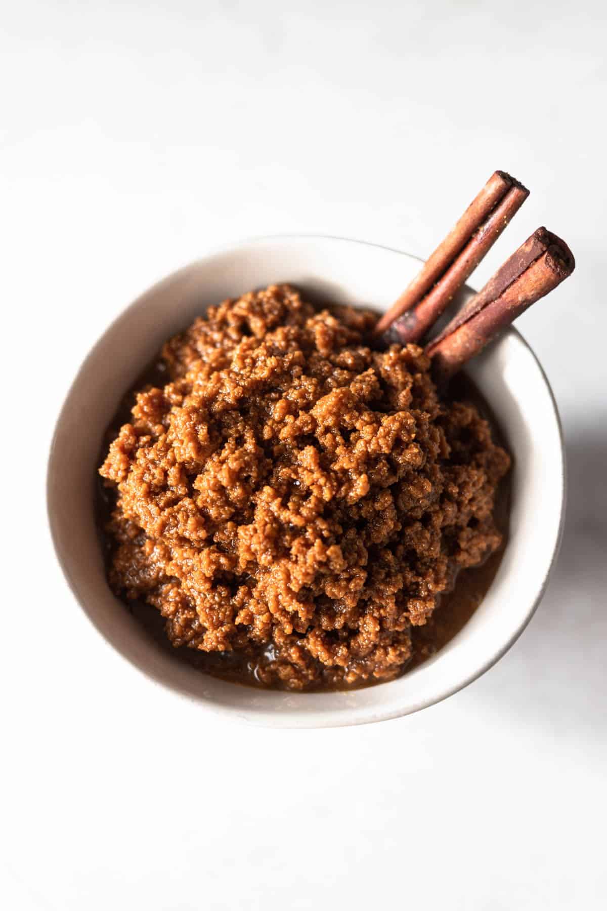 small bowl of doce leite garnished with cinnamon sticks