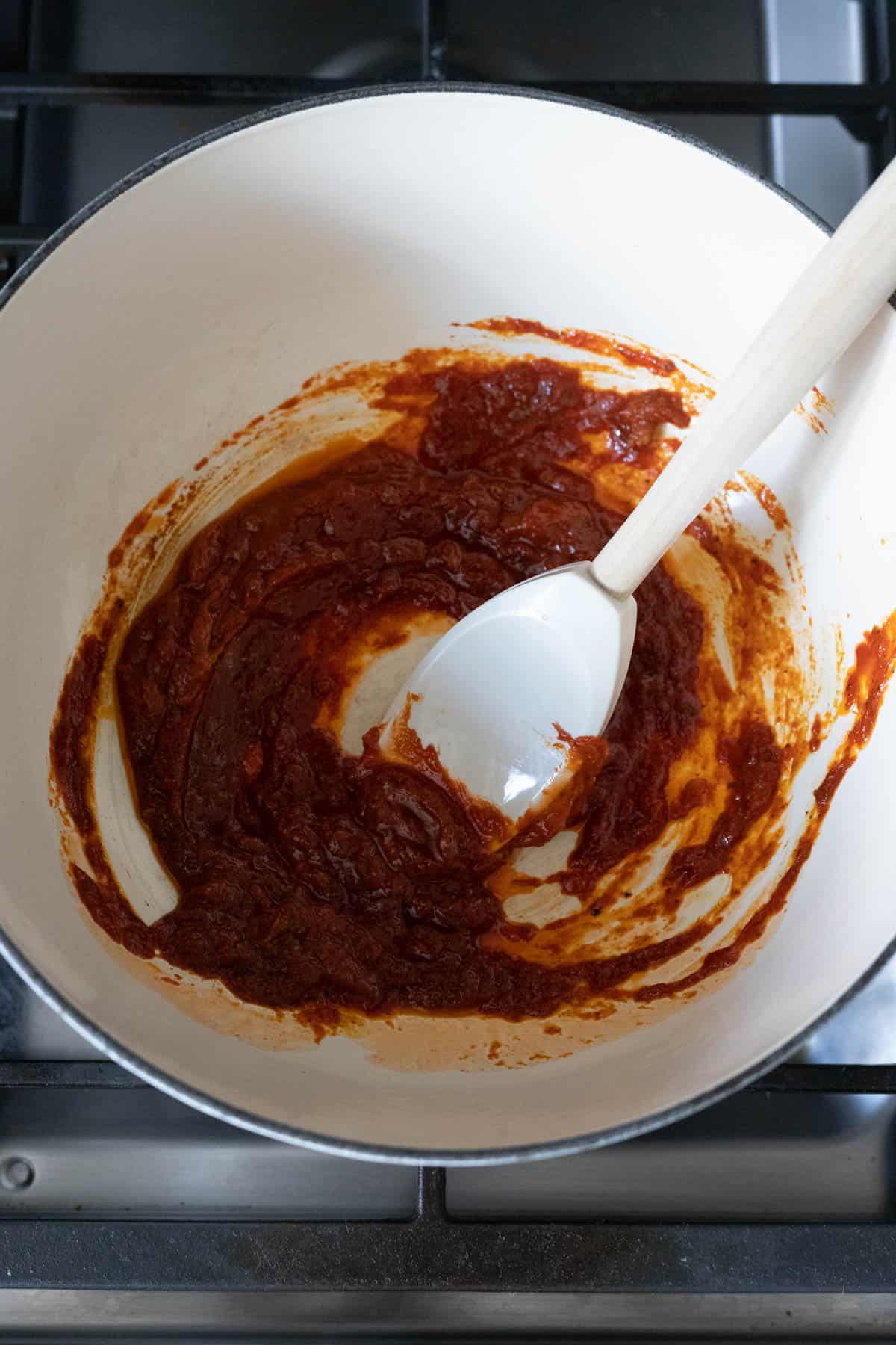 tomato paste and dry seasonings in a dutch oven pot on the stove.