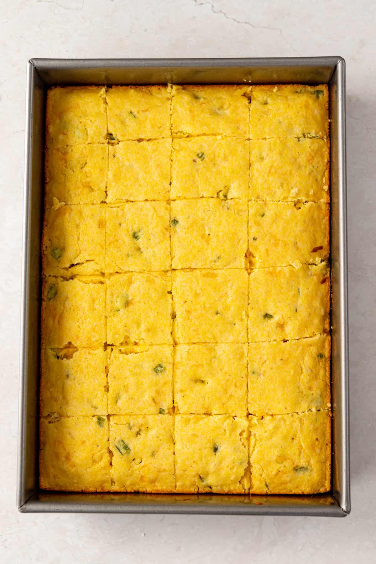 baked jalapeño cornbread made from jiffy mix cut into squares in the pan.
